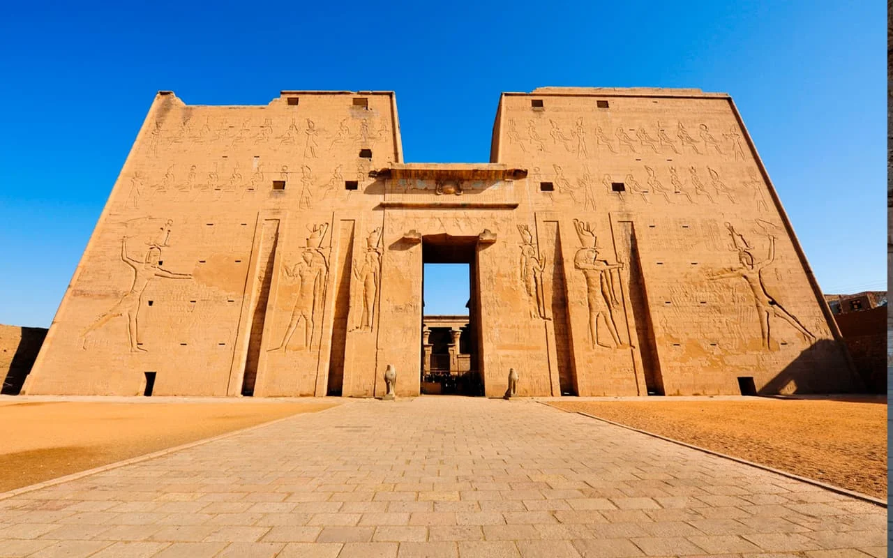 Imponente pilono de entrada al Templo de Edfu con relieves jeroglíficos para disfrutar en un viaje a Egipto todo incluido y paquetes a Egipto