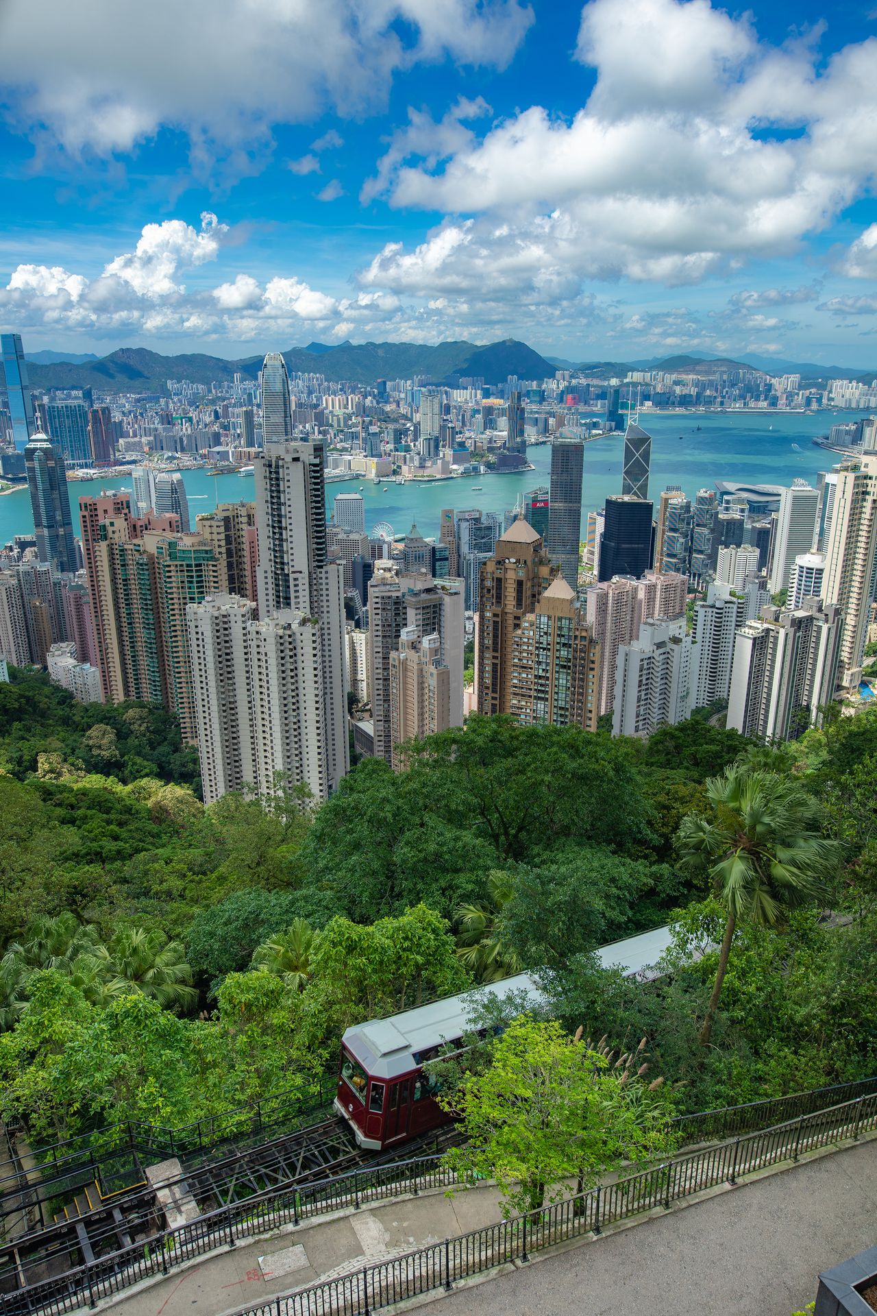 Vista panorámica de los rascacielos de Hong Kong y la bahía Victoria desde el Pico Victoria, con el tranvía histórico en primer plano, excursiones a Hong Kong desde Colombia