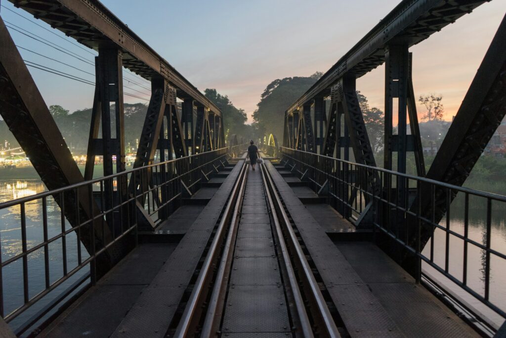 Atardecer sobre el histórico puente del Río Kwai en Kanchanaburi durante un viaje a Tailandia organizado.