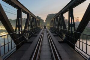 Atardecer sobre el histórico puente del Río Kwai en Kanchanaburi durante un viaje a Tailandia organizado.