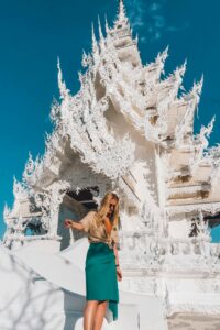 Turista contemplando la fachada del Templo Blanco durante un tour por Chiang Mai y el norte de Tailandia.
